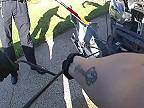 Žena uteká od auta, keď polícia vyberie z nárazníka hada