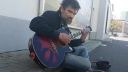 Bezdomovec Tomáš hrá na gitare pri bratislavskom markete (2017)