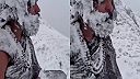 Sporo odetý zasnežený jogín medituje v mrazivom počasí