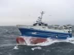 Rybárska loď v bojuje s masívnymi vlnami na rozbúrenom mori