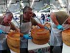Taliansky syrár rozkrajuje bochník syra „parmigiano reggiano“