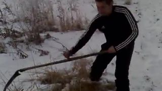 Domáci poľnohospodár kosí v zime seno pre kravky