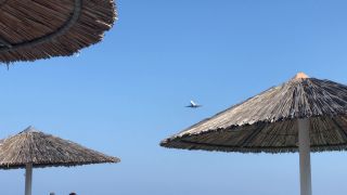 Prelet lietadla ponad pláž letoviska Kamari - Santorini