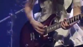 Japonka v kostýme slúžky hraje gitarové sólo.