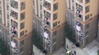 Otec s dieťaťom uniká z karantény po dlhom rebríku (Šanghaj)