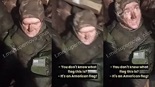 Zajatý okupant s vlajkou USA