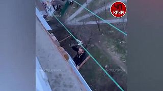 Muž s nožom lezie po balkóne