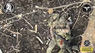 Okupant sa schováva pred dronom za stromom