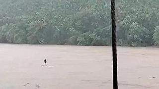 V rozvodnenej rieke uvideli muža, ktorý stál na plaviacom sa brvne (India)