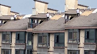 video Pani suší na streche výškovej budovy prádlo, zjavne jej výška neprekáža