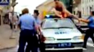 Nahý muž na policajnom aute
